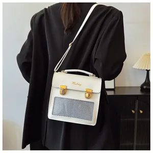 Close-up of stylish white PU leather shoulder bag with gold buckles and mesh window