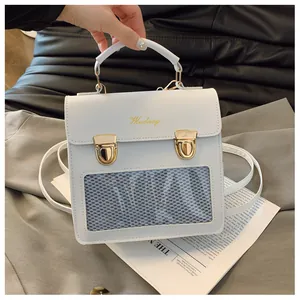 Close-up of white PU leather bag with transparent mesh window and gold metal buckles