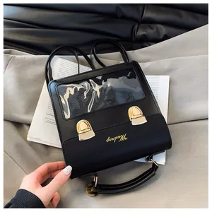 Detail view of the black leather bag featuring a clear window and gold buckle closures