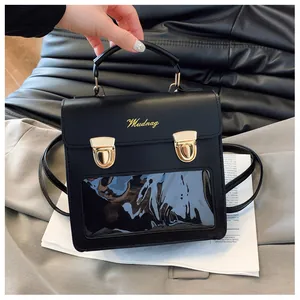 Detail of black leather bag with gold hardware and a rectangular clear display window