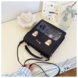 Close-up of black PU leather bag with transparent window and golden metal buckles