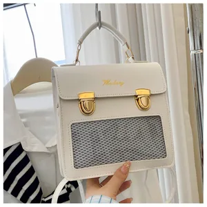 Detail of white vintage shoulder bag featuring gold buckles and breathable mesh window