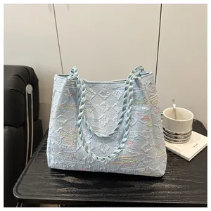 Detail of light blue tote bag with 3D diamond texture and thick woven rope handles