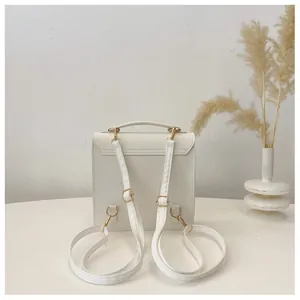 Rear view of white PU leather backpack showing adjustable straps and gold metal hooks