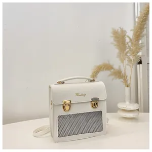 Detailed side view of white ita bag with clear mesh window and golden hardware accents
