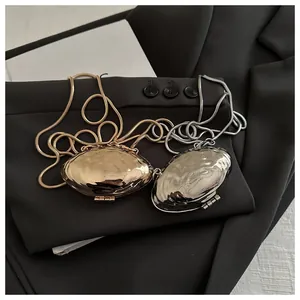 Detailed view of mini metallic shell bags in gold and silver with wavy hammered texture