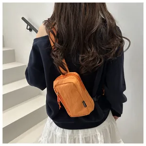 Detailansicht der orangen Nylon-Brusttasche mit Textur und Fashion-Label am Modell
