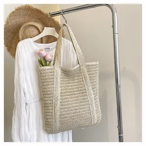 Detail of hollow woven straw tote bag texture and large capacity handle design for summer