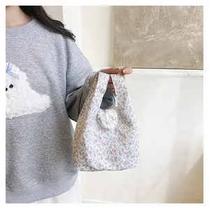 Close-up of small floral handbag with pink and purple flower pattern for daily use