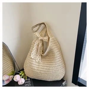 Détail du sac à bandoulière tissé blanc cassé avec texture ajourée et grand nœud en dentelle