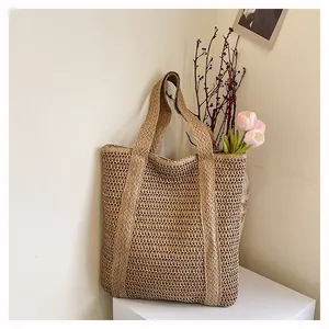 Macro view of woven hollow texture and thick straps on beige straw tote beach bag