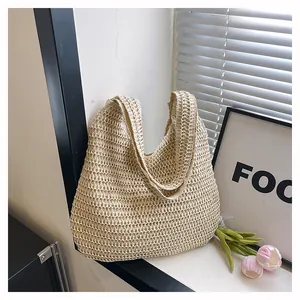 Détail du sac cabas en paille tissée beige avec texture ajourée délicate et tombé souple