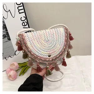 Gros plan détaillé du sac selle tissé avec broderie colorée et détails de glands