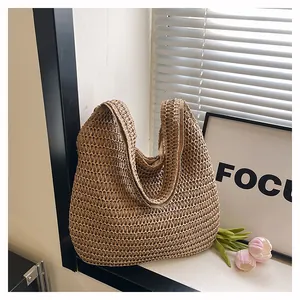 Gros plan détaillé du sac hobo en paille tressée avec texture naturelle et doublure