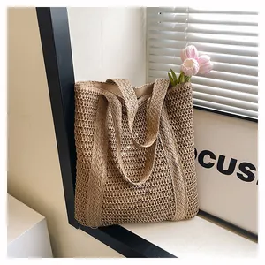 Close-up of woven hollow-out straw tote bag showing natural texture and sturdy handles