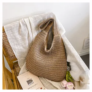 Détail du sac à épaule en paille tissé main avec doublure coton sur une chaise