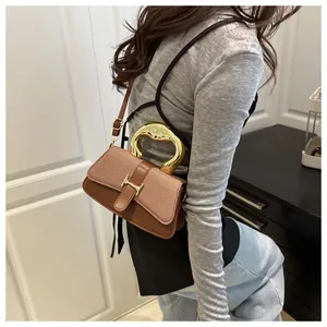 Close-up of brown woven leather handbag with golden semicircular handle and H-clasp