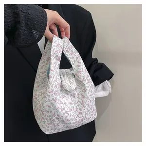Detail of floral canvas tote bag featuring pink and blue flower prints and blue checkered lining