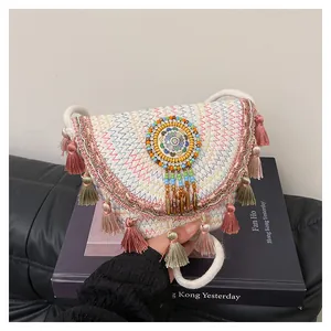 Détail du sac de selle ethnique avec coutures en zigzag et perles colorées brodées
