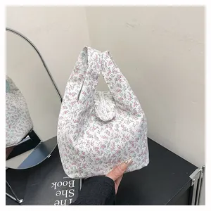 Detail of floral tote bag showing delicate ruffled handles and vintage flower pattern