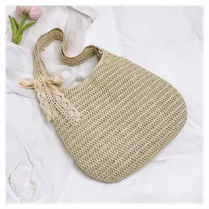 Détail d'un sac en paille tissé à la main avec un nœud décoratif en dentelle crème