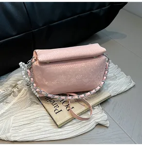 Detail of pink snake-pattern box bag with silver chain strap and pearl charm accent