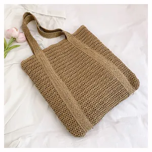 Detail of hand-woven straw tote bag with intricate texture and natural brown fibers