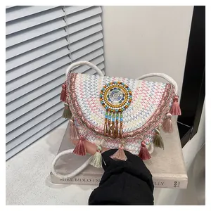 Détail du sac besace bohème avec coutures colorées, glands et broderie de perles fines