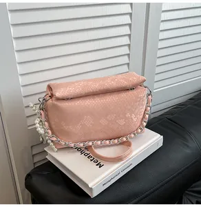 Pink snake pattern crossbody bag with silver chain and white pearl charm detail