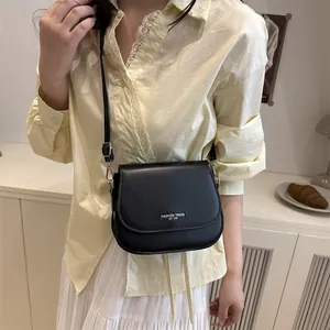 Minimalist black leather saddle bag for women with fashion trend logo on flap