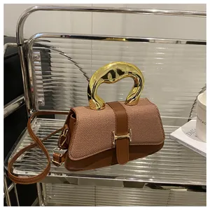 Detail of a brown textured crossbody bag with a large gold metal handle and H clasp