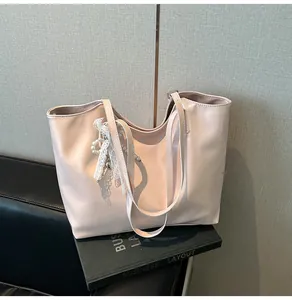 Dettaglio borsa tote rosa chiaro in pelle PU con ciondolo di pizzo e perle eleganti