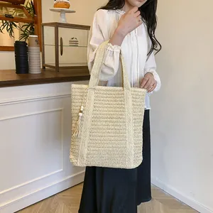 Straw hollowed-out tote bag in beige with tassel detail and large capacity for summer fashion
