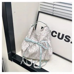 Close-up of floral tote bag featuring a light blue plaid bow and delicate flower patterns