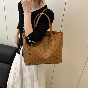 Brown vintage tote bag with bear print and leather handles carried by a model