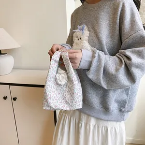 Chic floral handbag for women styled with casual sweatshirt and pleated skirt
