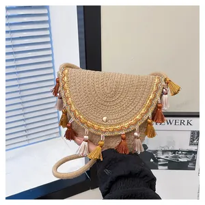Détail du sac selle en paille tressé avec des franges colorées et broderies fines