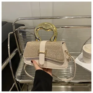 Detail of elegant cream leather handbag with sparkling rhinestone flap and gold H buckle