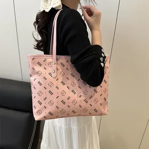 Pink faux leather tote bag with bear pattern and shoulder strap worn by a model