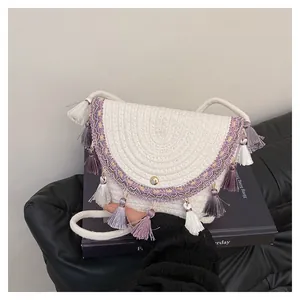 Détail de la bandoulière tressée beige avec franges multicolores et fermoir doré en métal