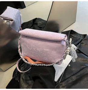 Detail of light purple snakeskin pattern handbag with silver chain and pearl lace charm