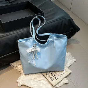 Borsa tote celeste in ecopelle con fiocco di pizzo e pendenti di perle bianche