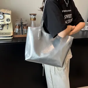Borsa tote argento metallizzato con spalline regolabili in un ambiente da caffetteria
