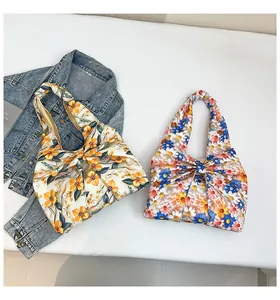 Flache Ansicht einer Blumentasche mit Schleife neben Jeansjacke und Magazin