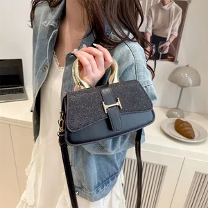 Women's black leather handbag with glittery flap and elegant gold metal handle
