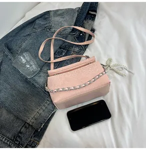 Detailed shot of pink snake pattern box bag with silver metal chain on casual clothing