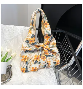Detail der Handtasche mit Blumenmuster, dekorativer Schleife und Faltenoptik