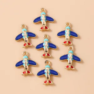 Detailed view of colorful airplane charms with gold edges and blue enamel for DIY crafts