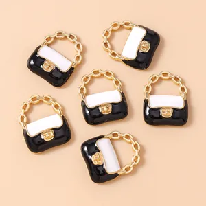 Detailaufnahme von sechs Mini-Handtaschen-Anhängern mit schwarz-weißem Emaille und Goldkette