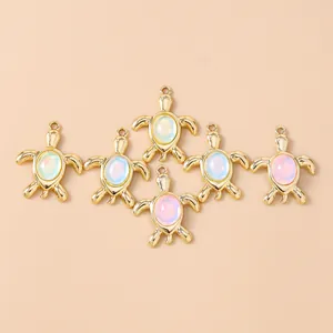 Detailed view of six golden turtle charms with iridescent opal inlay for DIY jewelry